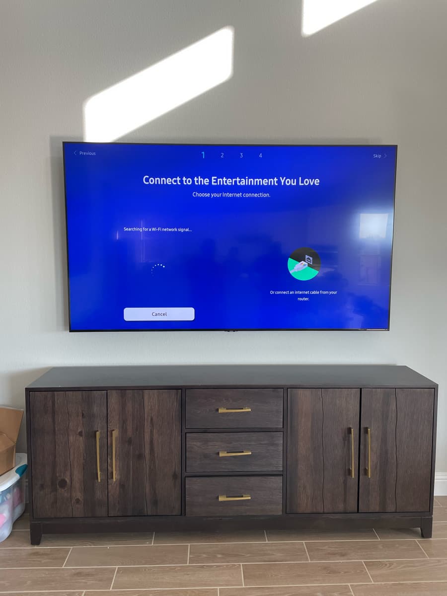 Flush TV wall mount with concealed wiring above a console in a Dallas living room
