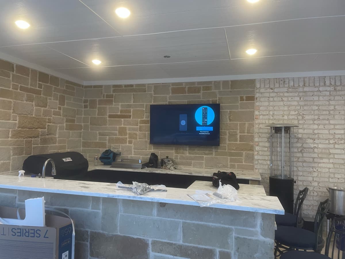 Outdoor patio with stone TV mount and hidden audio installation in Southlake TX