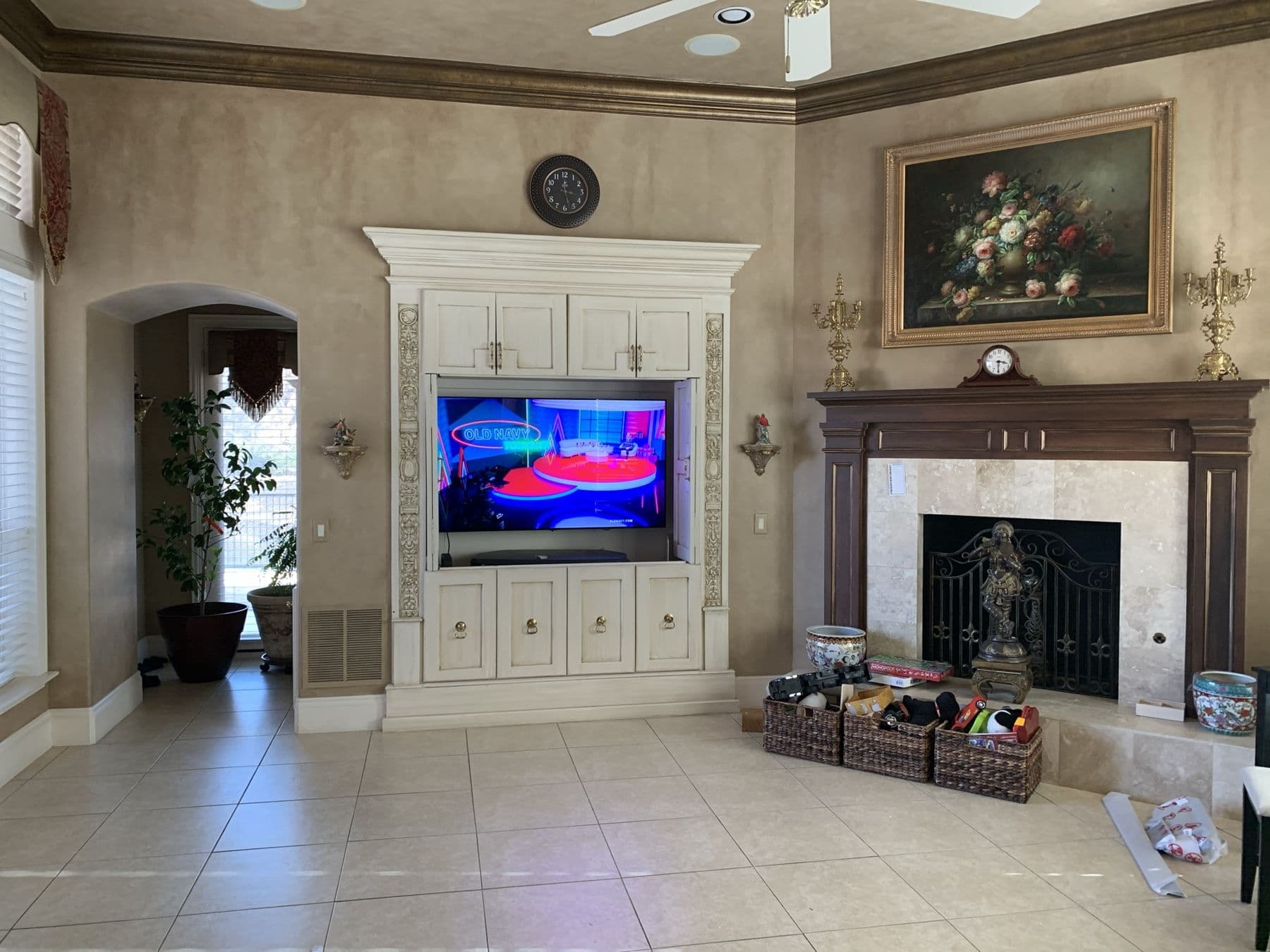 Flush TV mounted in an ornate luxury built-in with fireplace and art wall — zero visible wires — Cognito Media Services install, Highland Park TX