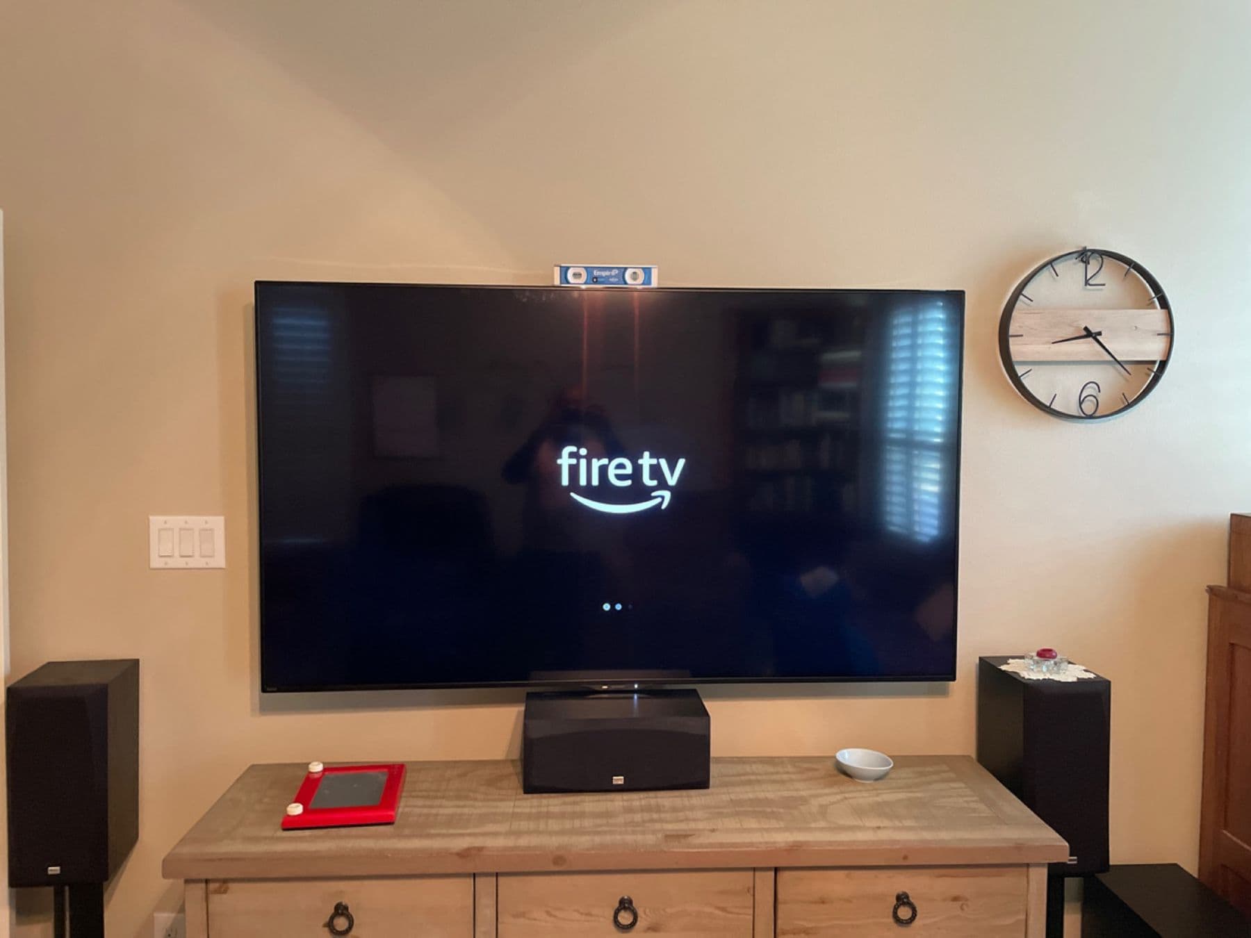 Wall-mounted TV with a center channel and bookshelf speakers on a media console, Dallas