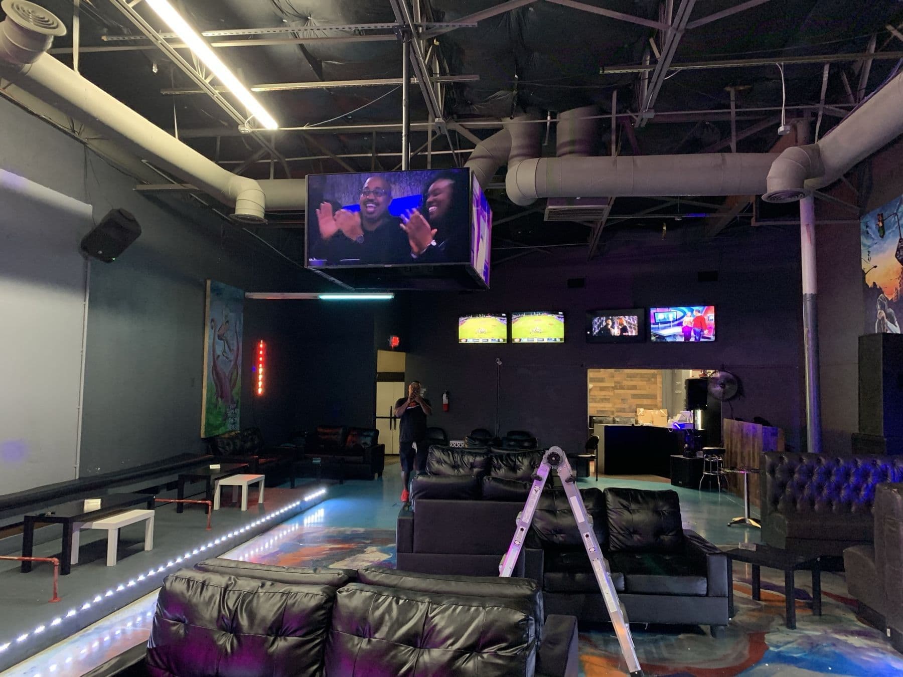 Multi-screen video wall and ceiling-hung TV cube in a Dallas sports lounge